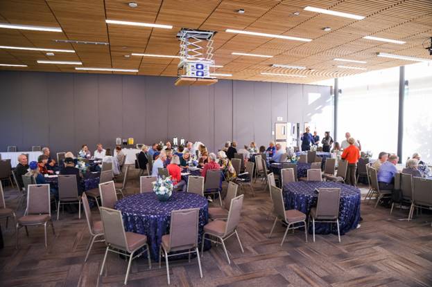 A group of people sitting around tables in a room

Description automatically generated