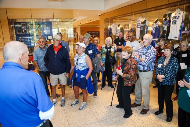 A group of people standing in a room

Description automatically generated